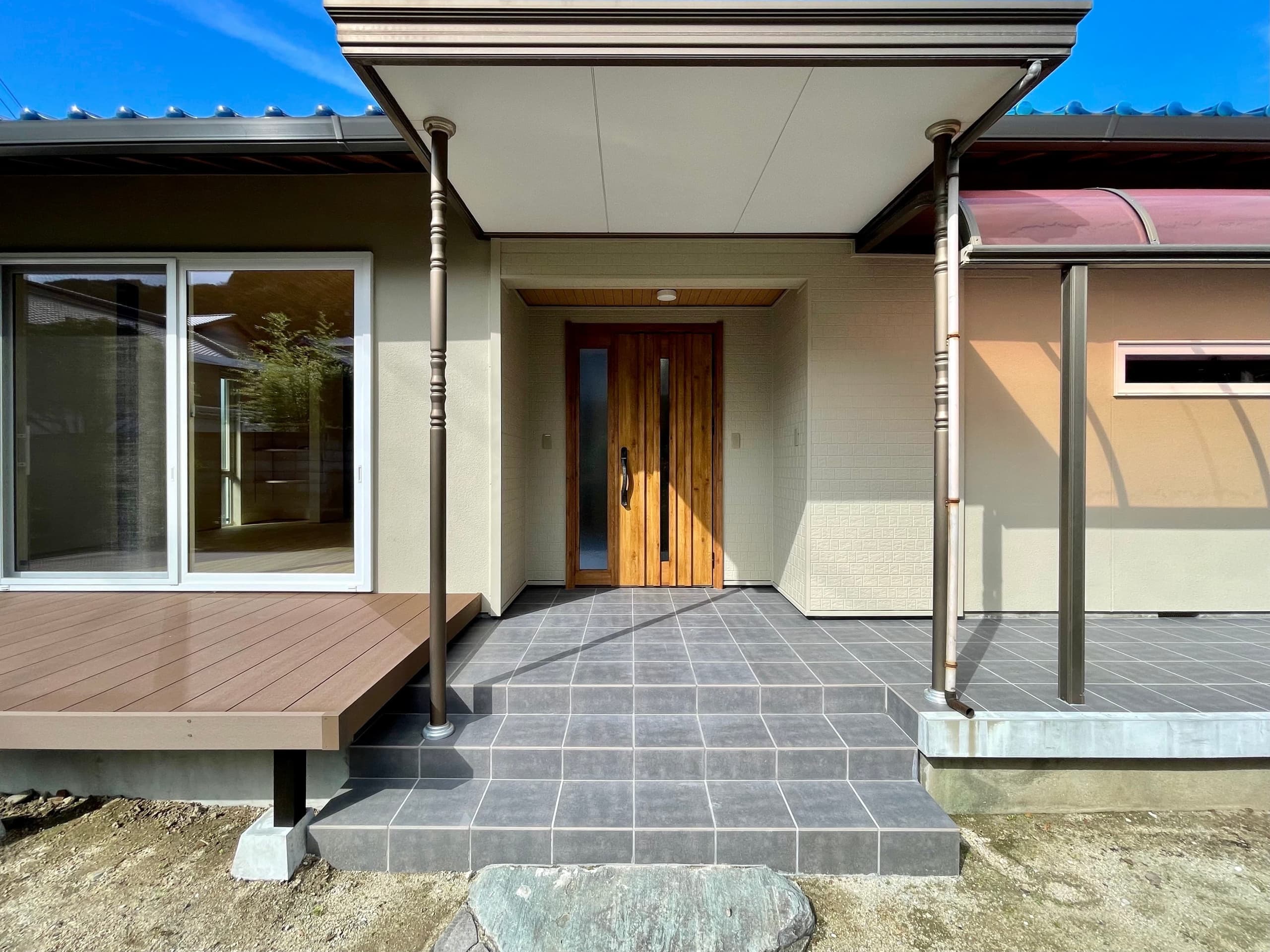 庇のついた玄関ポーチと、階段アプローチを備えた外観