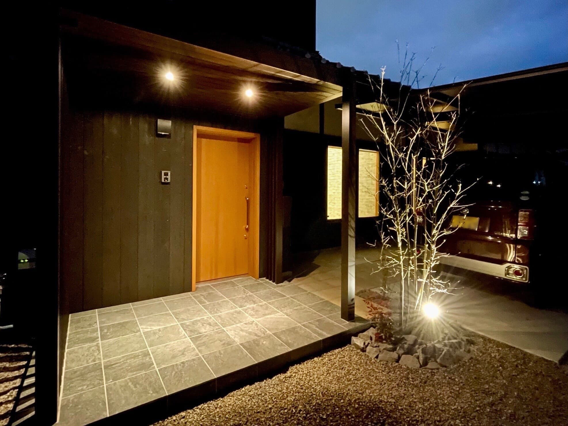 ライトアップされた植栽と玄関が織りなす、夜の和モダンな外観